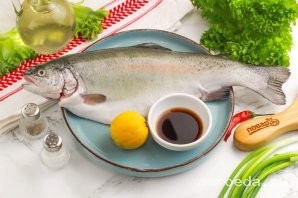 Шаг 1: Подготовьте указанные продукты. Форель очистите от чешуи и внутренностей, тщательно промойте тушку в воде внутри и снаружи. Половину лимона нарежьте кружочками, с одного из них выдавите сок.