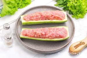 Шаг 10: Фарш выложите в половинки кабачки с запасом, так как при запекании "лодочки" существенно уменьшатся в размерах.