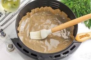 Шаг 4: Чашу аэрогриля застелите пергаментной бумагой и смажьте ее растительным маслом, чтобы не пристал ко дну.