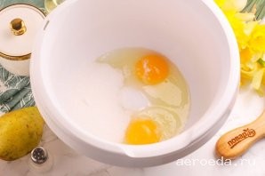 Шаг 4: Вбейте куриные яйца в емкость кухонного комбайна или миксера. Всыпьте сахарный песок и соль. Можно добавить ванильный сахар, пару щепоток молотой корицы. Взбейте в течение 3-4 минут в пышную пену.