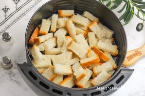 Шаг 13: Выложите нарезанный хлеб в чашу аэрогриля. Можно застелить ее пергаментной бумагой и тогда вам не нужно будет отмывать чашу от чеснока.