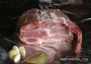 Шаг 1: Мясо промойте и обсушите. Поместите свинину на двойной лист фольги. Чеснок очистите.