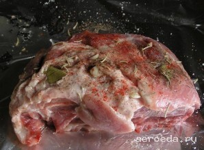 Шаг 4: Нарежьте зубчики чеснока дольками и нашпигуйте им мясо. Также натрите мясо солью, перцем, паприкой и оливковым маслом. Сверху кладем розмарин и лавровые листы.